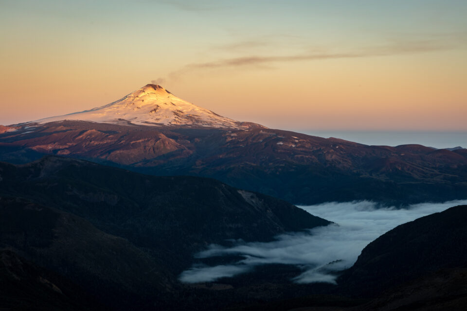 日出时，从附近的山上可以看到维拉里卡火山，稀薄的烟雾升入天空。